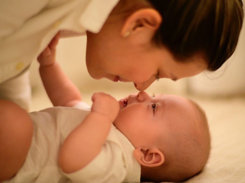 Une maman touchant le nez de son bébé avec son propre nez, par le dessus