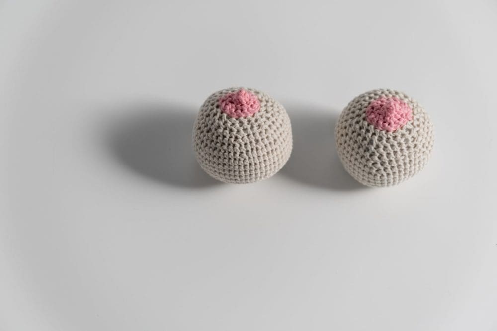 beige and pink knitted breast on white surface