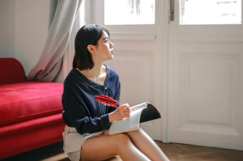 Une femme écrit dans son journal, pensive