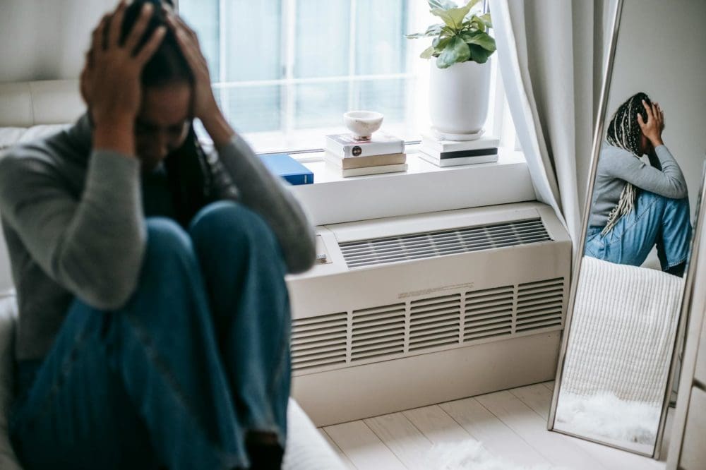 Une femme déprimée qui se prend la tête entre les mains